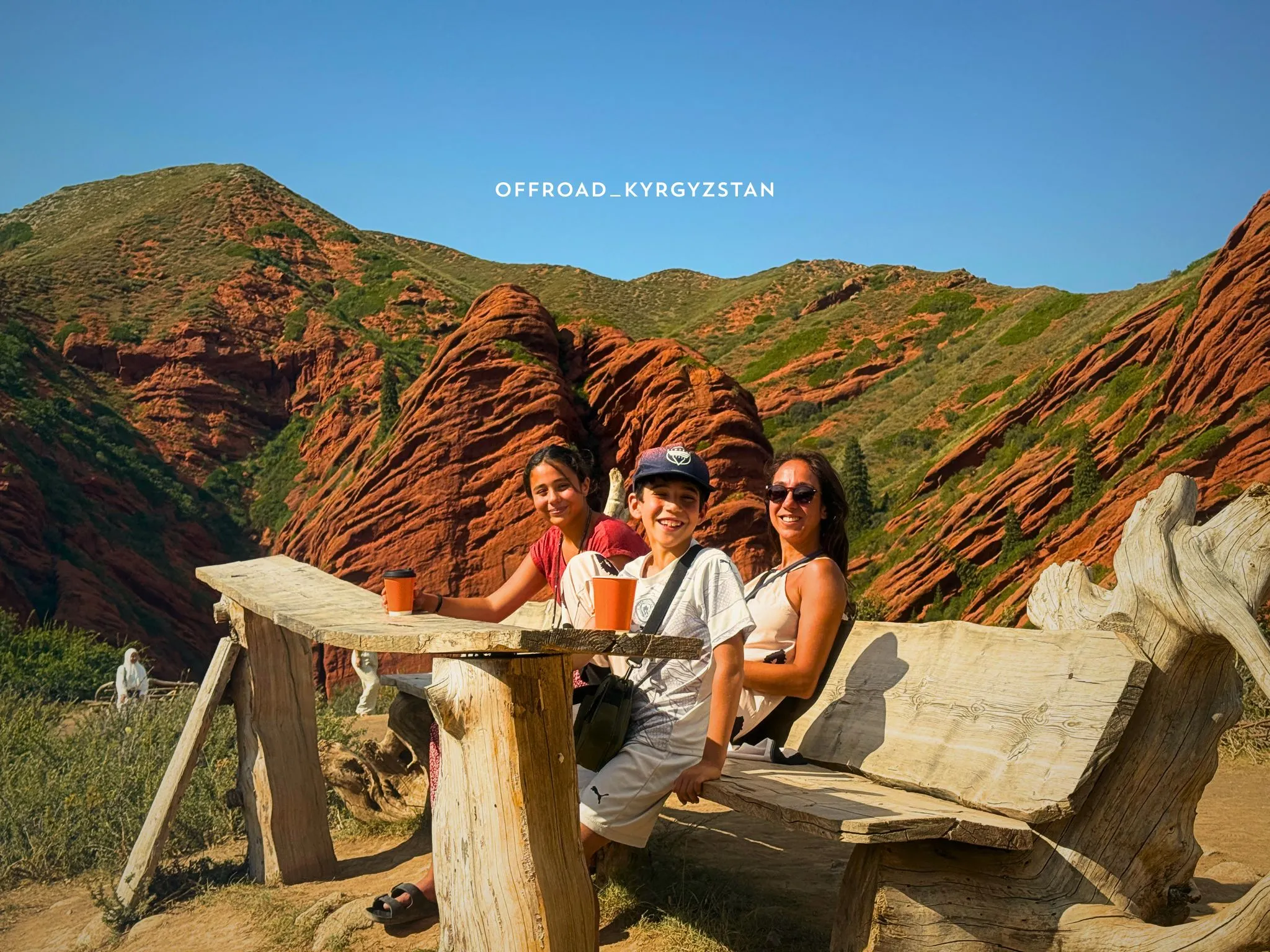 Family-friendly tour in Kyrgyzstan: parents and kids having a coffee break with a view of Jeti-Oguz mountains.